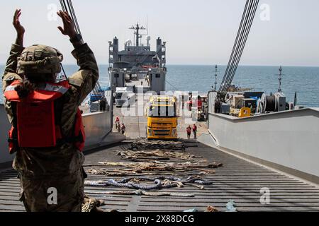 Mar Mediterraneo, Israele. 18 maggio 2024. Soldati dell'esercito statunitense assegnati alla 7th Transportation Expeditionary Brigade, dirigono il camion sul MV Roy P. Benavidez dalla Roll-on Roll-off Distribution Facility del Trident Floating Pier, 18 maggio 2024, a Gaza, territorio palestinese. Il molo galleggiante sarà utilizzato per spostare gli aiuti umanitari direttamente dalle navi alla terraferma per il popolo palestinese a Gaza. Credito: SSgt. Malcolm Cohens-Ashley/US Army Photo/Alamy Live News Foto Stock