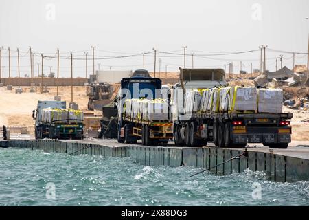 Mar Mediterraneo, Israele. 18 maggio 2024. Camion che trasportano aiuti umanitari escono dal molo galleggiante del Tridente verso la spiaggia, 18 maggio 2024, a Gaza, territorio palestinese. Il molo galleggiante sarà utilizzato per spostare gli aiuti umanitari direttamente dalle navi alla terraferma per il popolo palestinese a Gaza. Credito: SPC. Riley Anfinson/US Army Photo/Alamy Live News Foto Stock