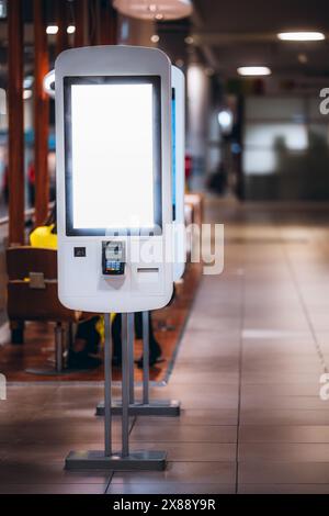 Vista verticale del modello di chiosco di una rinomata catena di fast food che si ordina da soli. Un modello di schermo vuoto che fonde perfettamente tecnologia e praticità Foto Stock