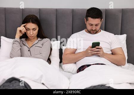 Una coppia offesa si ignorava a vicenda dopo una lite a letto. Problemi di relazione Foto Stock