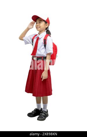 Ritratto di una studentessa asiatica delle scuole elementari in uniforme con uno zaino e un gesto rispettoso isolato su uno sfondo bianco Foto Stock