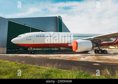 Un Airbus A330 senza marchio con coperchi motore parcheggiati per manutenzione all'aeroporto internazionale di Malta Foto Stock