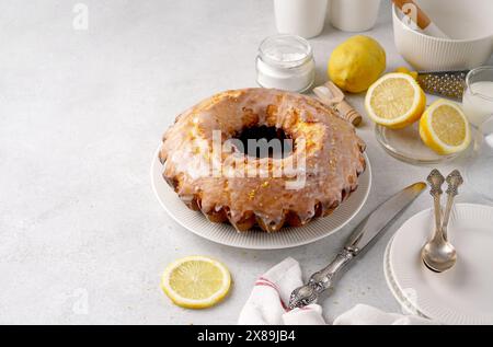 Torta al limone con glassa di zucchero a velo su un tavolo leggero Foto Stock