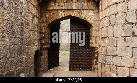 Porta d'ingresso del forte con unghie di ferro affilate su di esso, Bhuikot Killa, Solapur, Maharashtra, India. Foto Stock