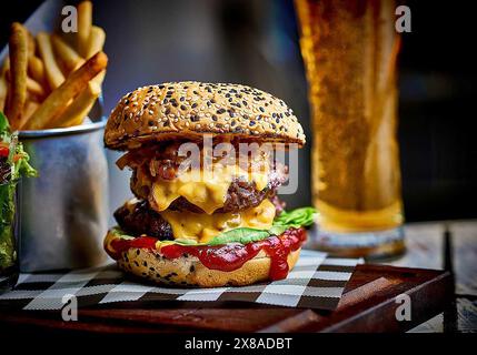 deliziosi hamburger di manzo con pancetta, formaggio e patatine fritte Foto Stock