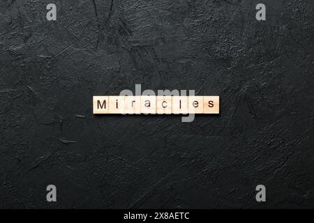 La parola miracoli scritta su blocco di legno. Miracoli testo su tavola di cemento per il vostro desing, concetto. Foto Stock