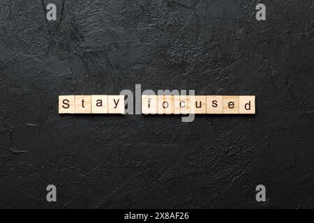 rimani concentrato parola scritta sul blocco di legno. rimani concentrato testo su tabella, concetto. Foto Stock