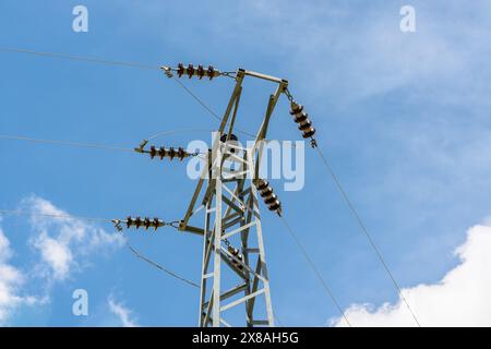 Isolanti in ceramica su poli elettrici e fili elettrici che li passano su di essi Foto Stock