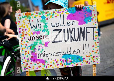 Brema, Germania. 24 maggio 2024. Un bambino ha in mano un poster con lo slogan "vogliamo aiutare a plasmare il nostro futuro!" Durante una dimostrazione da parte del "Bildungswende jetzt!" alleanza alla Conferenza dei Ministri della gioventù e della famiglia (JFMK). Sotto la presidenza di Brema, i ministri responsabili e i senatori degli stati federali vogliono discutere argomenti come l'inclusione e la partecipazione, lo spazio sociale e l'orientamento familiare, il reclutamento del personale e la sicurezza dei lavoratori qualificati. Credito: Sina Schuldt/dpa/Alamy Live News Foto Stock