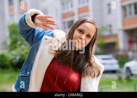 Una donna sta ballando energicamente nella foresta. Trasuda fiducia e gioia mentre si muove con grazia. Foto Stock