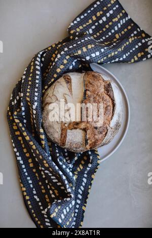 Pane rustico su un piatto con un panno a motivi geometrici Foto Stock