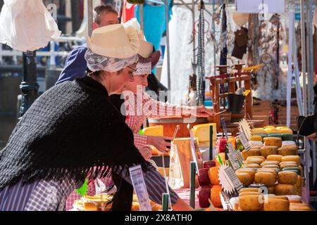 Venditrice con abbigliamento tradizionale in una bancarella al mercato del formaggio di Alkmaar. Foto Stock