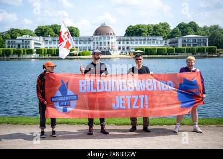 Brema, Germania. 24 maggio 2024. Dimostranti del "Bildungswende jetzt!" alliance stand con uno striscione di fronte a Hollersee presso il Parkhotel durante la Conferenza dei Ministri della Gioventù e della famiglia (JFMK). Sotto la presidenza di Brema, i ministri responsabili e i senatori degli stati federali vogliono discutere argomenti come l'inclusione e la partecipazione, lo spazio sociale e l'orientamento familiare, il reclutamento del personale e la sicurezza dei lavoratori qualificati. Credito: Sina Schuldt/dpa/Alamy Live News Foto Stock