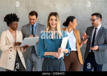 Ritratto di un gruppo multietnico di diversi colleghi aziendali in fila in un ufficio moderno Foto Stock