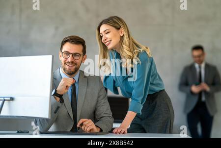 Uomini d'affari con colleghi commercianti in ufficio che monitorano i dati delle scorte sullo schermo analizzando il flusso dei prezzi Foto Stock