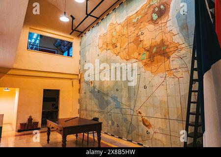 Una grande mappa della Sicilia è appesa sul muro di un bunker dell'era della seconda guerra mondiale al museo Lascaris War Rooms di Malta, con una scrivania in legno e una scala Foto Stock