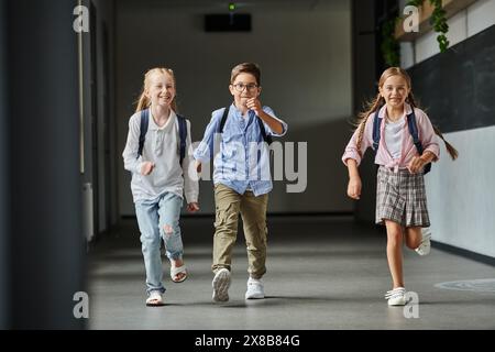 gruppo di bambini piccoli che camminano con gioia lungo un corridoio luminoso Foto Stock