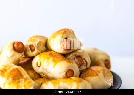 Salsicce nell'impasto su un piatto di ceramica sul tavolo. Foto Stock