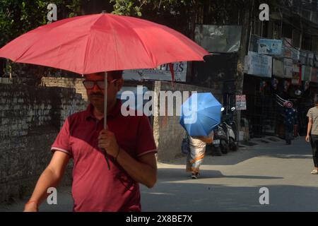 Siliguri, Bengala Occidentale, India. 24 maggio 2024. L'uomo indiano usa un ombrello per sbarazzarsi del sole rovente durante una calda giornata estiva a Siliguri. La temperatura è di 41 gradi a Siliguri oggi. (Credit Image: © Diptendu Dutta/ZUMA Press Wire) SOLO PER USO EDITORIALE! Non per USO commerciale! Foto Stock