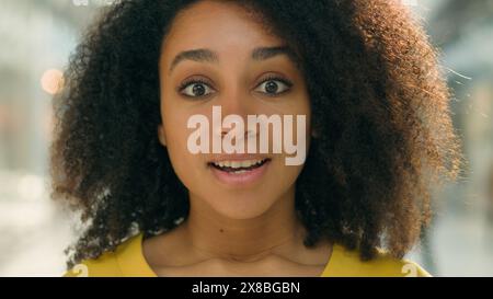 Primo piano donna afroamericana felice che guarda la fotocamera sorprende sorprende sorprende sorprende entusiasta ragazza modella espressione facciale bocca aperta gioiosa Foto Stock