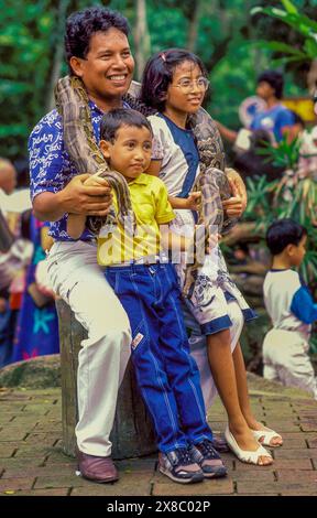 Singapore, padre che posa con i suoi figli e un grande Python nello zoo. Foto Stock