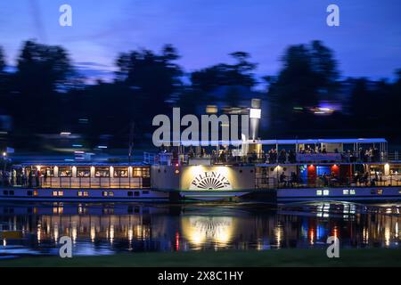 Dresda, Germania. 23 maggio 2024. Lo storico piroscafo a pale "Pillnitz" della Sächsische Dampfschifffahrt (compagnia di navi a vapore sassone) naviga sull'Elba verso la città vecchia in serata. (Girato con un lungo tempo di esposizione) credito: Robert Michael/dpa/Alamy Live News Foto Stock