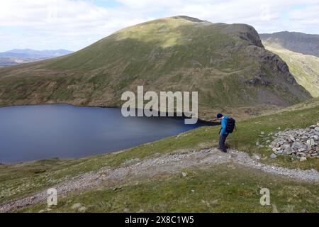 Lone Man (escursionista) camminando lungo il Wainwright 'Fairfield' fino a Grisedale Hause e Grisedale Tarn nel Lake District National Park, Cumbria, Inghilterra, Regno Unito. Foto Stock