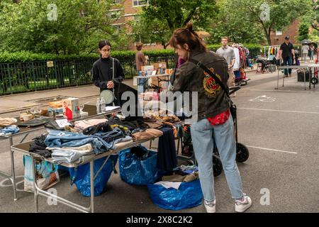 Gli amanti dello shopping cercano occasioni presso l'annuale mercato delle pulci Penn South, nel quartiere di Chelsea, New York, sabato 18 maggio 2024. Il mercato delle pulci appare come Brigadoon, solo una volta all'anno, e i residenti della cooperativa Penn South di 20 edifici hanno uno stravagante servizio di pulizia dell'armadio. Gli amanti dello shopping provenienti da tutta la città vengono al mercato delle pulci che attrae migliaia di visitatori. (© Richard B. Levine) Foto Stock