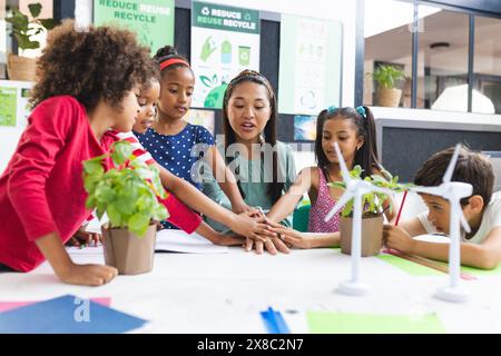 A scuola, diversi gruppi di studenti e il loro insegnante si stanno impegnando con le piante in classe Foto Stock