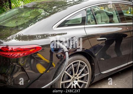 Il conducente carica il proprio veicolo elettrico BMW presso una stazione di ricarica per veicoli elettrici Chargepoint a Chelsea, New York, sabato 18 maggio 2024. (© Richard B. Levine) Foto Stock