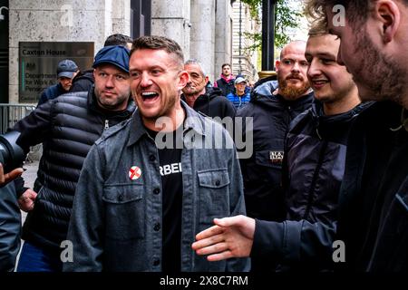 Dopo aver vinto Una causa contro la polizia Met, Un sorridente Tommy Robinson (alias Stephen Yaxley-Lennon) lascia Un St Georges Day Rally, Londra, Regno Unito. Foto Stock