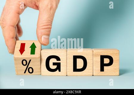 Concetto di prodotto interno lordo. GDP scritto su blocchi di legno, icona con la freccia giù. Politica monetaria, finanziaria, gestione, economica, inflazione, Busi Foto Stock
