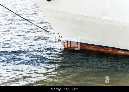 Una barca è ancorata saldamente in acqua con una corda legata ad essa. Foto Stock