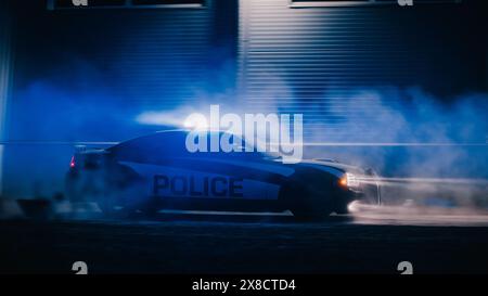 Autostradale per la pattuglia del traffico in Pursuit of Criminal Vehicle. Agenti di polizia in Squad Car Chase sospetto su strada durante una notte nebbiosa. Area industriale cinematografica. Scena d'azione Foto Stock