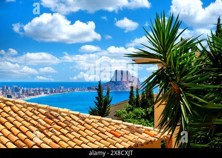 Calpe, vista sul mare e sul Penyal d'IFAC con palme e tetto di casa in primo piano, Costa Blanca, Spagna Foto Stock