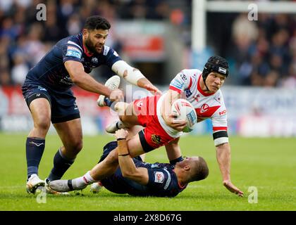 Jonny Lomax dei Saint Helens viene placcato durante il Betfred Super League match al Totally Wicked Stadium, St. Helens. Data foto: Venerdì 24 maggio 2024. Foto Stock