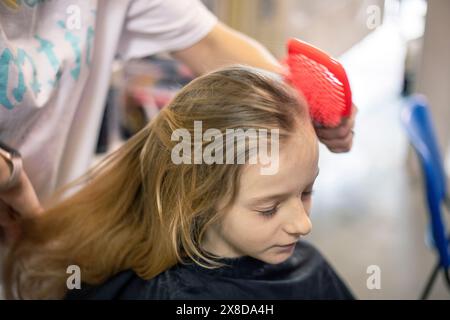 lo stylist fa i capelli di una ragazza prima di partecipare a un torneo di ballo in sala da ballo Foto Stock