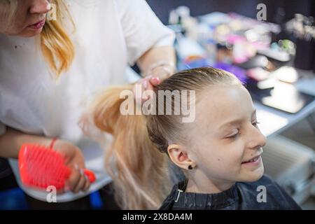 lo stylist fa i capelli di una ragazza prima di partecipare a un torneo di ballo in sala da ballo Foto Stock