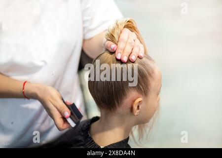 lo stylist fa i capelli di una ragazza prima di partecipare a un torneo di ballo in sala da ballo Foto Stock