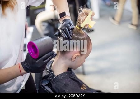 lo stylist fa i capelli di una ragazza prima di partecipare a un torneo di ballo in sala da ballo Foto Stock