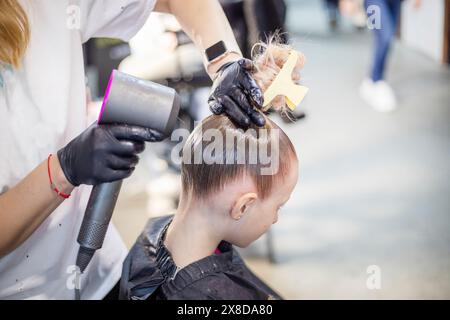 lo stylist fa i capelli di una ragazza prima di partecipare a un torneo di ballo in sala da ballo Foto Stock