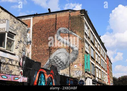 ROA, l'artista di strada belga, dipinse una gru, sacra per Bengalis, proprio nel cuore della loro comunità a Brick Lane, a est di Londra, Regno Unito Foto Stock