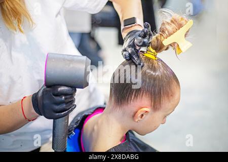 lo stylist fa i capelli di una ragazza prima di partecipare a un torneo di ballo in sala da ballo Foto Stock