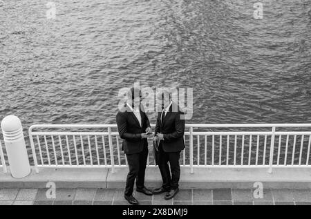 Allegro uomo d'affari medio-orientale a piedi per strada verso un moderno edificio di uffici. Ritratto di persone di successo business all'aperto, parlando insieme Foto Stock