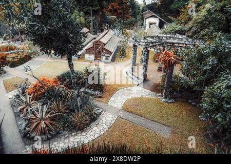 Vista aerea di un giardino botanico splendidamente paesaggistico caratterizzato da sentieri in pietra, vegetazione lussureggiante, varie piante succulente e pittoreschi verdau in legno Foto Stock