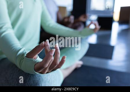 Una coppia diversa a casa, meditando insieme in pace Foto Stock