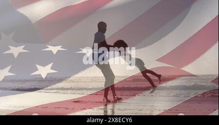 Padre e figlia afroamericani in abbigliamento casual che giocano sulla spiaggia Foto Stock