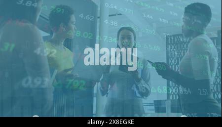 Immagine di un comitato commerciale, diverse colleghe che discutono di tenere un notebook e un tablet digitale Foto Stock