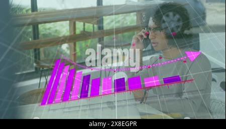 Immagine di una freccia sul grafico che cade e veicolo per strada, uomo birazziale che parla al cellulare Foto Stock