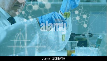 Scienziato maschio anziano caucasico che versa liquido nella provetta Foto Stock